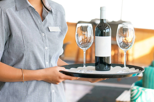 Офіціантка носить пляшку вина
 - Фото, зображення