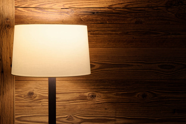Vloerlamp tegen houten wand - Foto, afbeelding