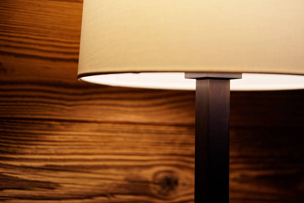 Luz de una lámpara de pie en una pared de madera
 - Foto, imagen