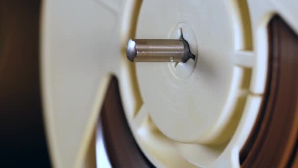 Zoom-in of a metal stem in a rotating tape reel - Video, Çekim