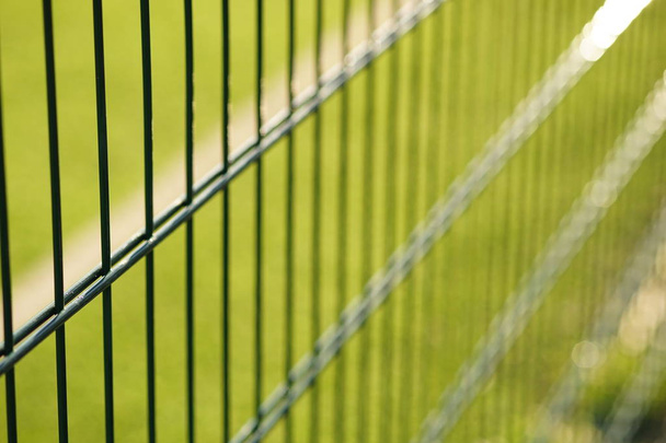 сетка зеленого забора на фоне газона для игры в мини-футбол
 - Фото, изображение