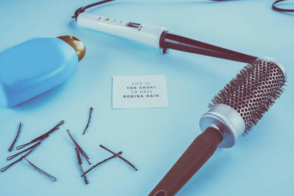 concepto de peluquería: cepillo de pelo, solla, horquillas sobre un fondo azul
 - Foto, Imagen