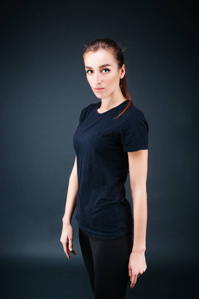 sporty-looking girl in a black T-shirt and leggings - Фото, изображение