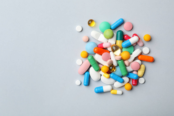 Heap of different pills on grey background, top view. Space for text - Foto, Imagem