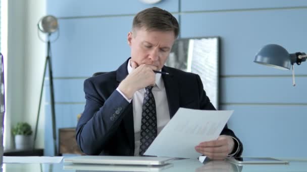 Businessman Reading Documents in Office - Video