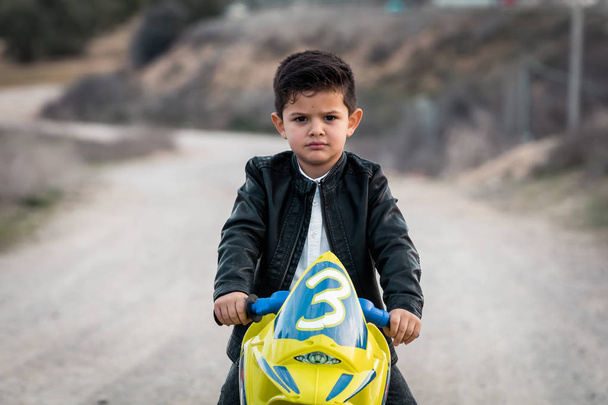 Dühös kisfiú lovaglás a motorkerékpár-játék - Fotó, kép