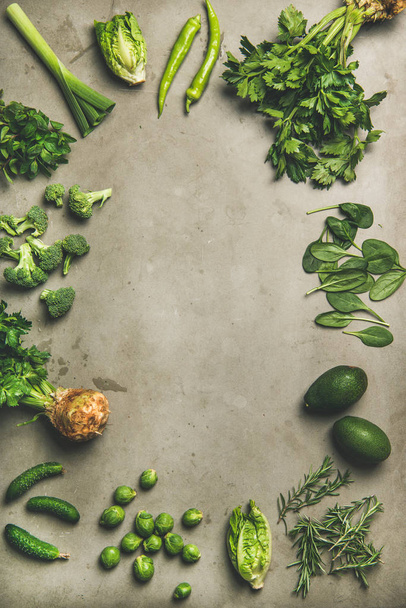 Gezonde Vegan ingrediënten lay-out. Flat-lay van verschillende groene groenten en kruiden over betonnen achtergrond, bovenaanzicht, kopieer ruimte, verticale samenstelling. Vegetarisch, schoon eten, licht voedsel concept - Foto, afbeelding