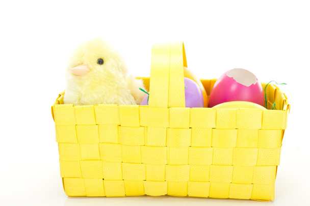 Little chick in a basket with some colorful Easter eggs - 写真・画像