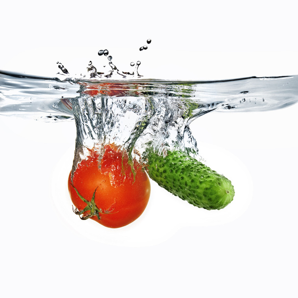 Red tomato and green cucumber in water - Valokuva, kuva