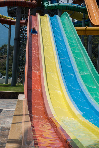 The boy rides a slide in the water park - Photo, Image