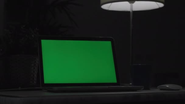Yeşil ekranlı dizüstü bilgisayar. Karanlık ofis. Dolly çekimi. Kendi resminizi veya videonuzu koymak için mükemmel. Yeşil ekran teknoloji kullanılıyor. Renk Anahtar dizüstü bilgisayar - Video, Çekim
