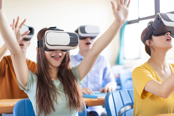 教室で新しい技術VRヘッドセットを楽しむ学生 - 写真・画像