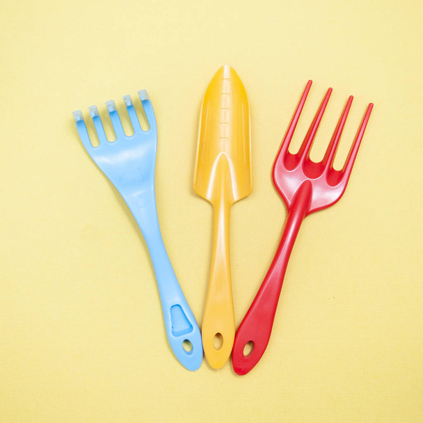 Garden tools, shovel, rake on a yellow background, flat lay - Fotografie, Obrázek