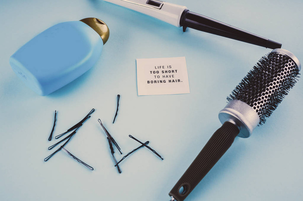 Friseurkonzept: Bürste, Scholle, Haarnadeln auf blauem Hintergrund - Foto, Bild