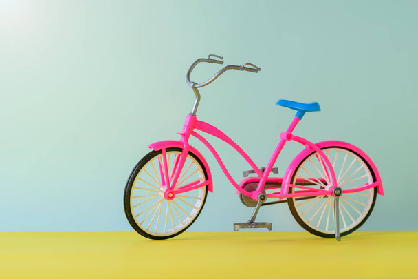 Speelgoed rode fiets voor een gele en blauwe achtergrond. - Foto, afbeelding