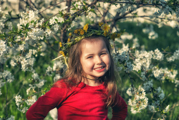 Portrait of a little girl in a flowering tree . - Foto, imagen