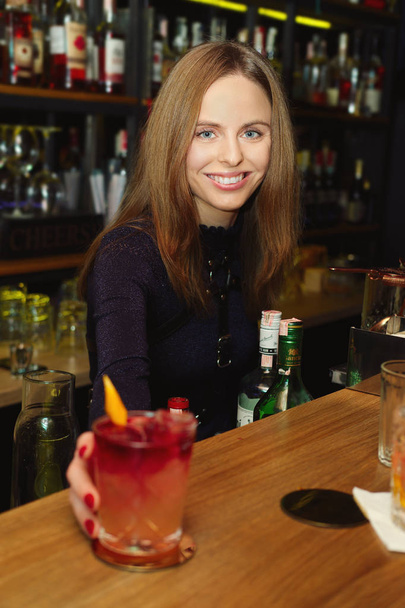 Bartender girl serving coctail to a customer - Fotoğraf, Görsel