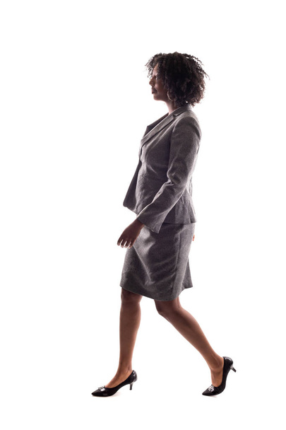 Side View of a Black Businesswoman walking in side view isolated on a white background. - Foto, afbeelding