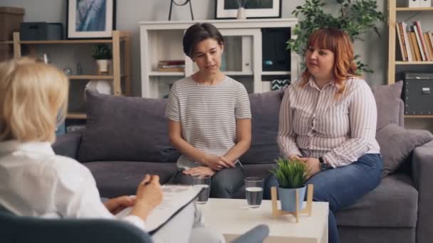 Female friends having conversation with psychotherapist talking gesturing - Video, Çekim