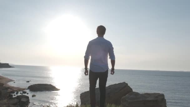 silhouette d'un homme au bord de la mer au lever du soleil
 - Séquence, vidéo