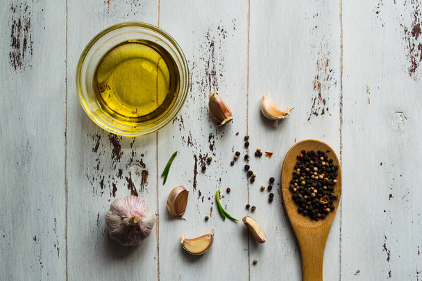 Olivový olej, koření a česnek na bílém dřevěném pozadí. - Fotografie, Obrázek