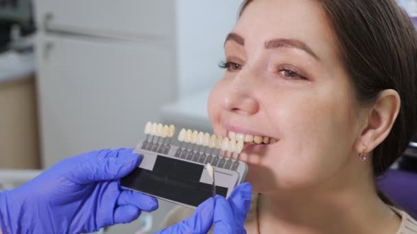 Diş rengi örnekleri ile Diş Hekimi diş kliniğinde kadın hasta dişleri için gölge seçiyor. - Video, Çekim