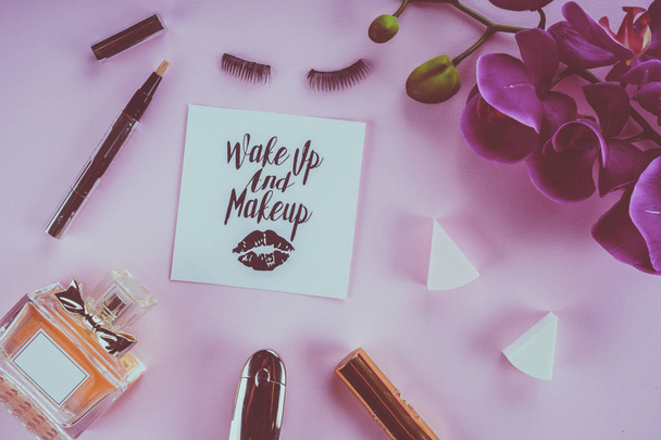 make-up tools op een roze achtergrond en de orchideebloem - Foto, afbeelding