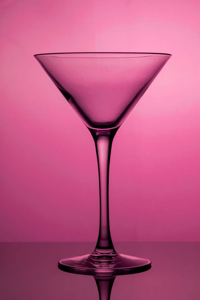 Cocktail glass, the stemmed glass is lit with purple light - Foto, Bild