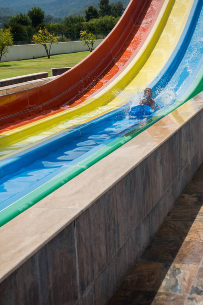 Хлопчик катається на гірці в аквапарку
 - Фото, зображення