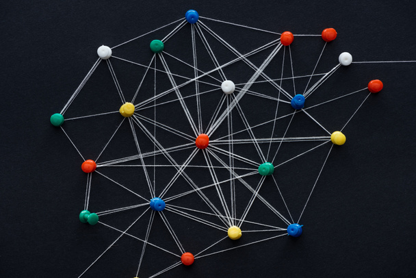 top view of push pins connected with strings isolated on black, network concept - Photo, Image