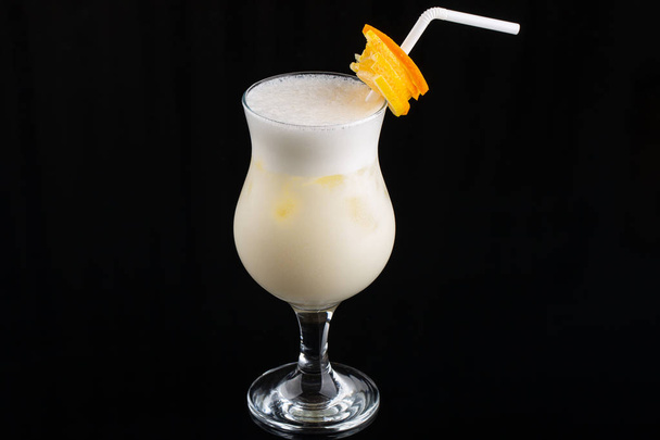 Pina Colada Cocktail - sweet cocktail made with rum, coconut cream or coconut milk garnished with pineapple wedge, selective focus - Photo, Image