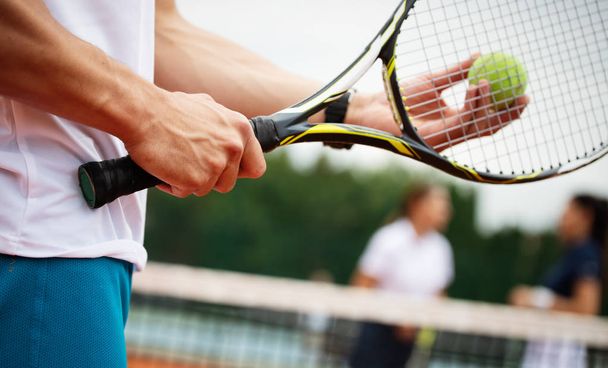 Happy fit people playing tennis together. Sport concept - Фото, изображение