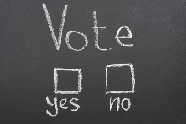 vista superior del voto blanco, sí y sin letras en pizarra negra
 - Foto, Imagen