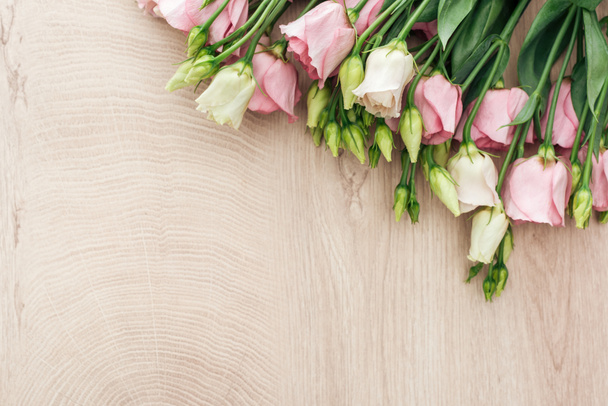 kopya alanı ile ahşap masa üzerinde eustoma çiçek buket üst görünümü - Fotoğraf, Görsel