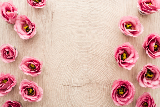 コピースペース付きの木製テーブル上のピンクのエウストマの花の上の眺め - 写真・画像