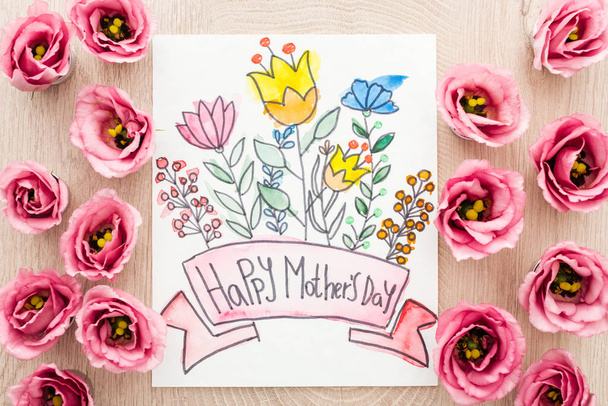top view of eustoma flowers and card with happy mothers day writing on table - Fotó, kép