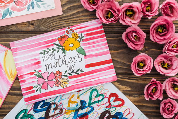 木製のテーブルに書き込み幸せな母親の日とエウストマの花とカードのトップビュー - 写真・画像