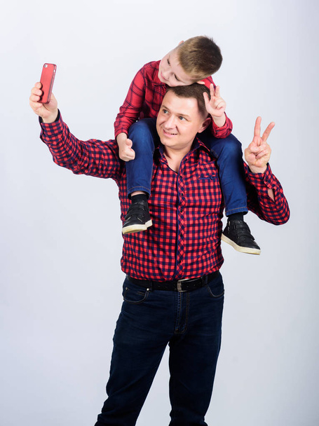 childhood. parenting. funny selfie with father. Happy family together. father and son in red checkered shirt. fathers day. Enjoying time together. small boy with dad man. Achieving success - Фото, изображение