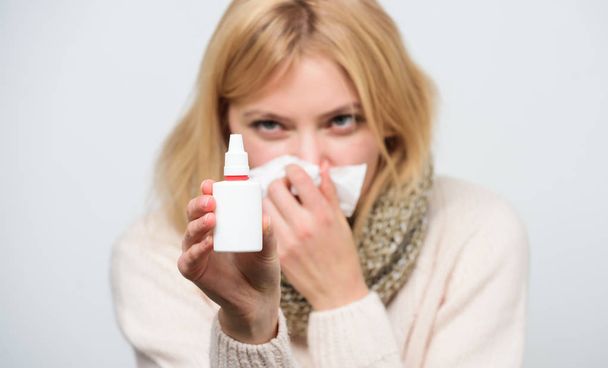 Relieving itchy nose. Cute woman nursing nasal cold or allergy. Sick woman spraying medication into nose. Treating common cold or allergic rhinitis. Unhealthy girl with runny nose using nasal spray - Foto, imagen