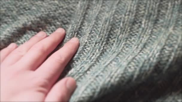 Mannelijke hand aanraken van een gladde groene trui in een textiel winkel. Close-up opname. - Video