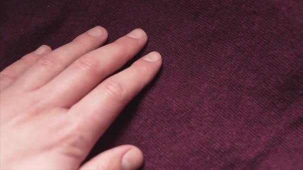 Hand aanraken van een gladde Bourgondië kleur acryl weefsel in een textiel winkel. - Video