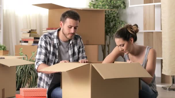 Sad couple boxing belongings moving home after eviction - Footage, Video