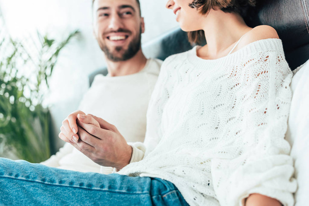 cropped view of happy man and woman holding hands at home  - Photo, Image