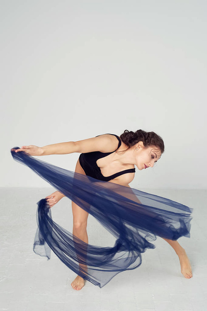 A slender gymnast in black tights dances with a blue chiffon that develops.Aesthetics of dance - Fotoğraf, Görsel