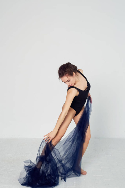 A slender gymnast in black tights dances with a blue chiffon that develops.Aesthetics of dance - Foto, Imagen