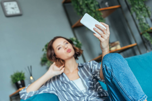 selective focus of woman with duck face taking selfie at home  - Photo, Image