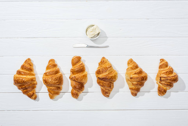 top view of knife near bowl with cream cheese and croissants on white   - Fotoğraf, Görsel