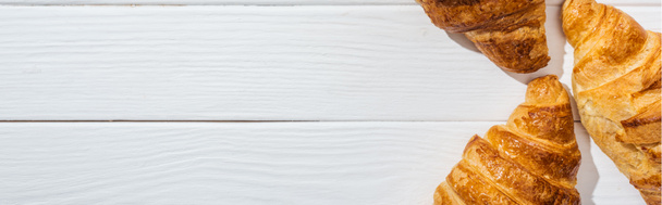 plano panorámico de croissants sabrosos y frescos en la superficie blanca
  - Foto, imagen