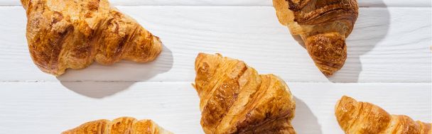 plano panorámico de croissants sabrosos y dulces en la superficie blanca
  - Foto, imagen