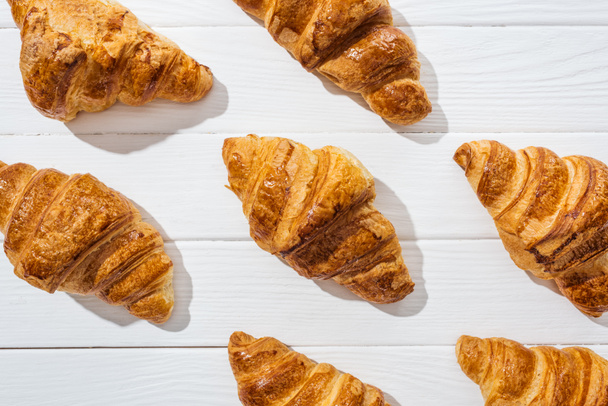 flat lay of delicious and sweet croissants on white surface  - Foto, Imagem